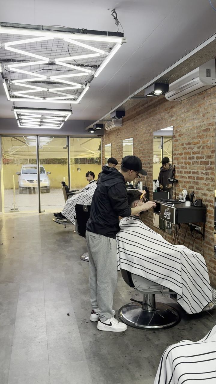 Los barberos cortando en el salón